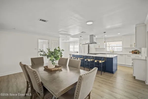 a kitchen with kitchen island a dining table and chairs