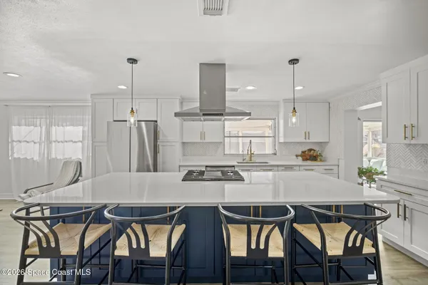 a kitchen with a dining table chairs and refrigerator