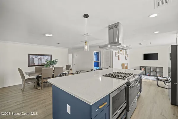 a kitchen that has a stove a table and chairs in it
