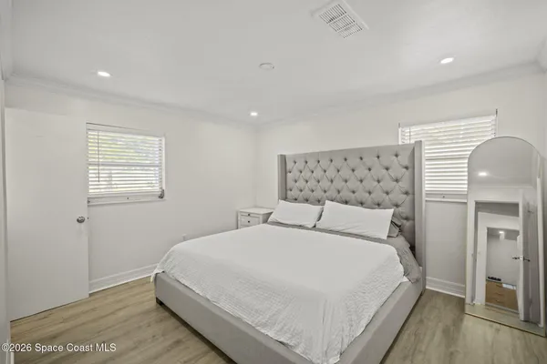 a large bed sitting in a bedroom next to a window