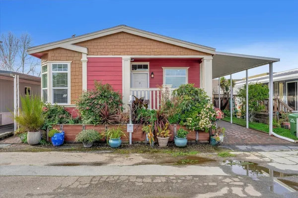 a front view of a house with a yard and potted plants