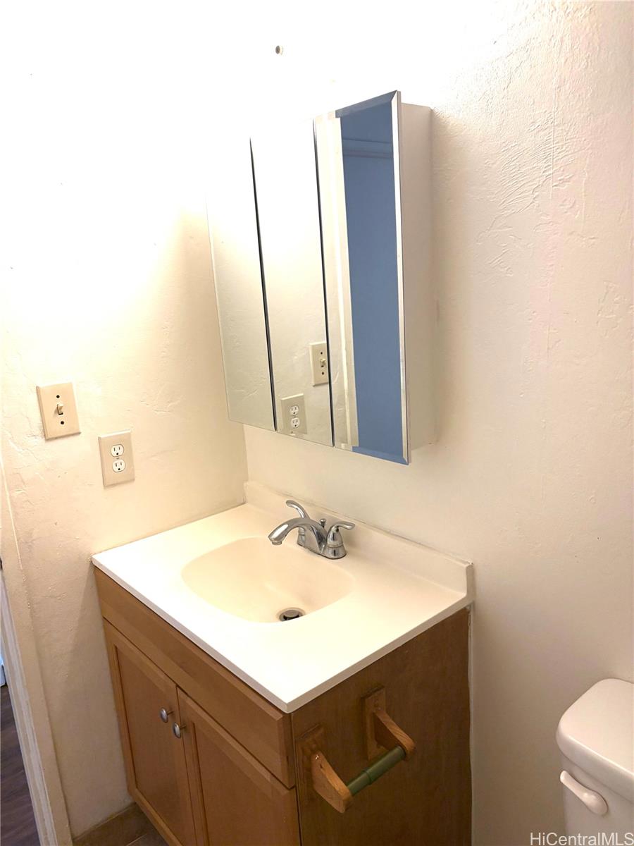 87-122 Helelua Street, Unit C204 Waianae, HI 96792 - Photo 3 of 14 a bathroom with a sink vanity and a mirror