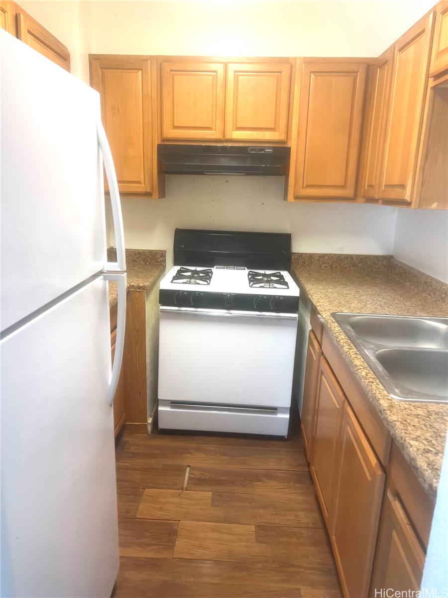 87-122 Helelua Street, Unit C204 Waianae, HI 96792 - Photo 4 of 14 a kitchen with a stove top oven and cabinets