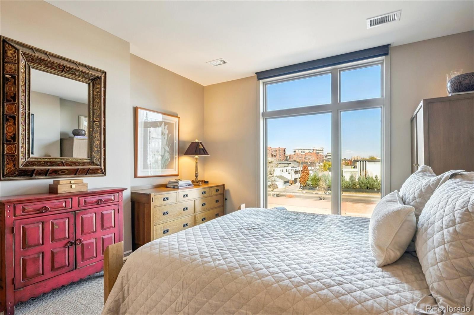 333 South Monroe Street, Unit 310 Denver, CO 80209 - Photo 15 of 33 a bedroom with a bed and a large window with kitchen view