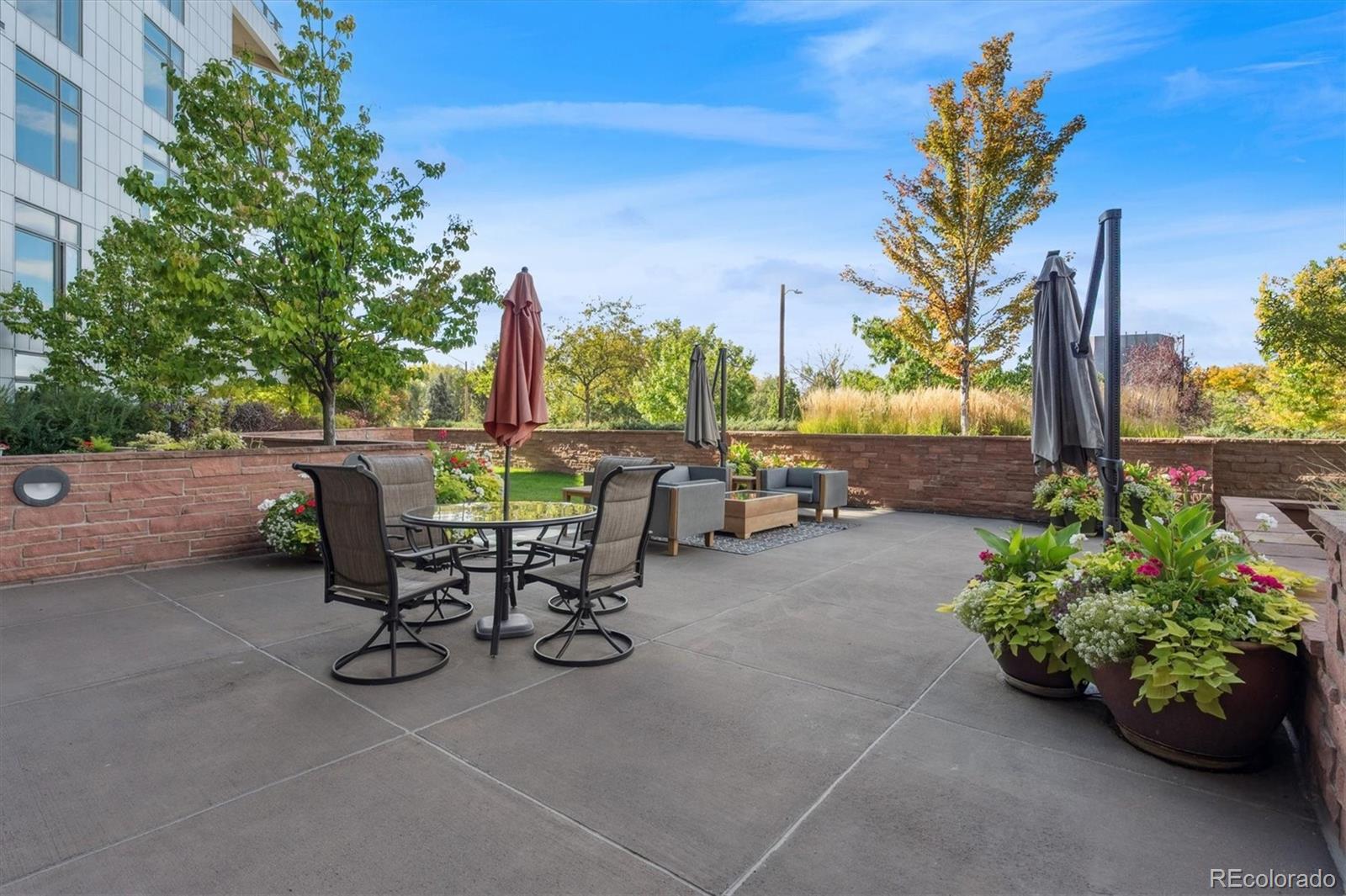333 South Monroe Street, Unit 310 Denver, CO 80209 - Photo 29 of 33 a view of a backyard with table and chairs potted plants and palm tree