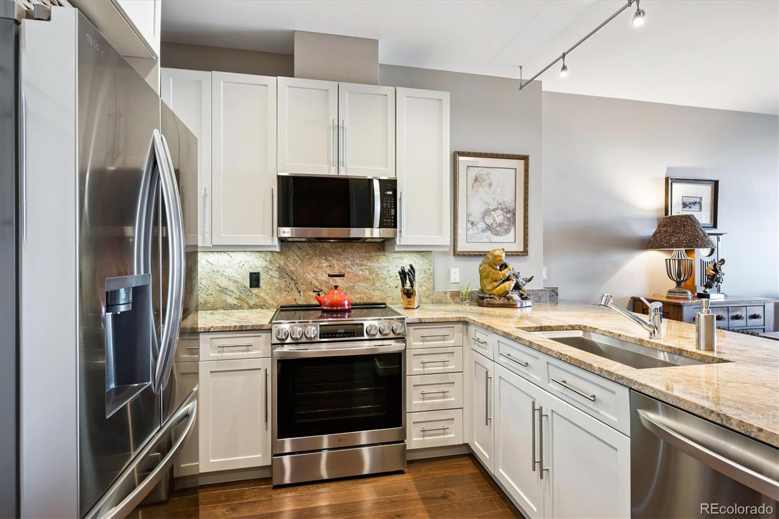 333 South Monroe Street, Unit 310 Denver, CO 80209 - Photo 7 of 33 a kitchen with stainless steel appliances a stove microwave and refrigerator