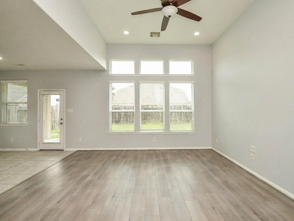 7042 Sliding Rock Circle Spring, TX 77379 - Photo 6 of 36 Spacious living room with high ceilings, large windows for natural light, and elegant flooring. Perfect for relaxation and entertaining.