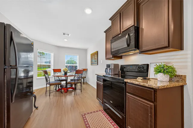 a kitchen with stainless steel appliances granite countertop a refrigerator stove microwave and sink