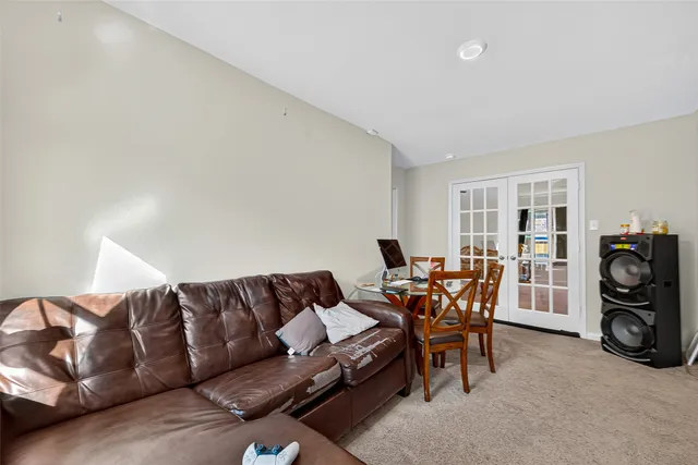 a living room with furniture and a dining table with chair