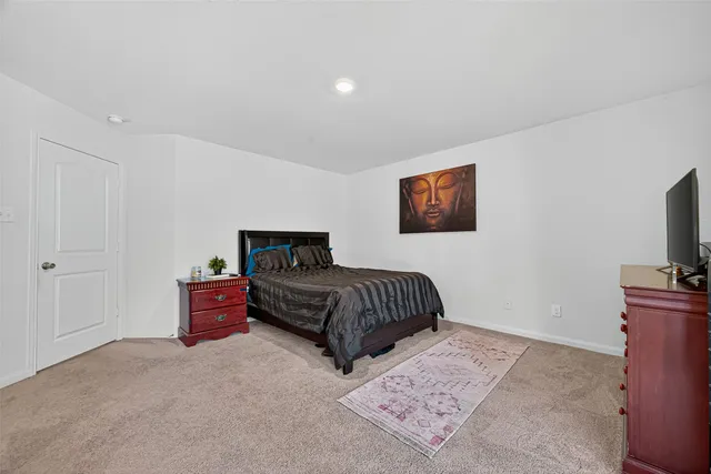 a bedroom with bed and a flat screen tv