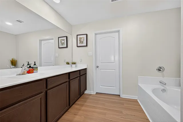 a bathroom with a tub sink and mirror