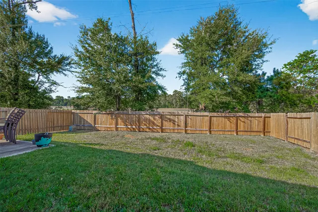 a view of a yard with a fence and trees