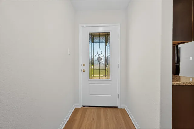 a view of a small space with wooden floor and a window
