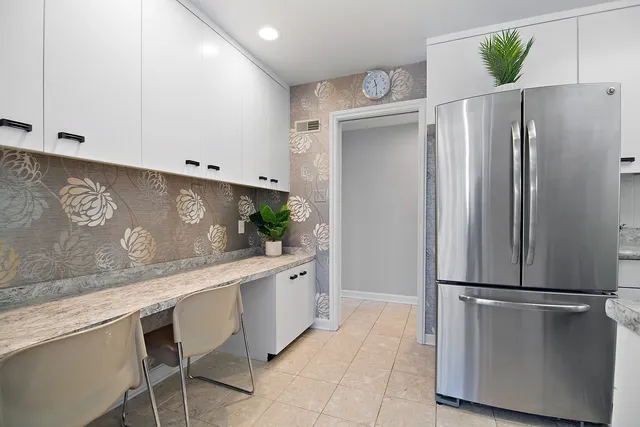 a kitchen with stainless steel appliances a refrigerator and a cabinets