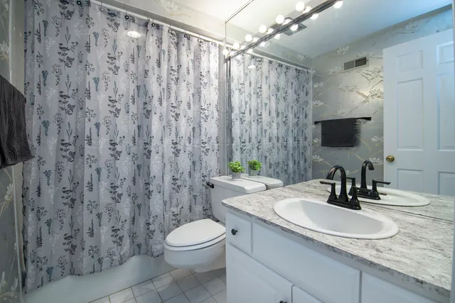 a bathroom with a granite countertop sink a toilet and a mirror