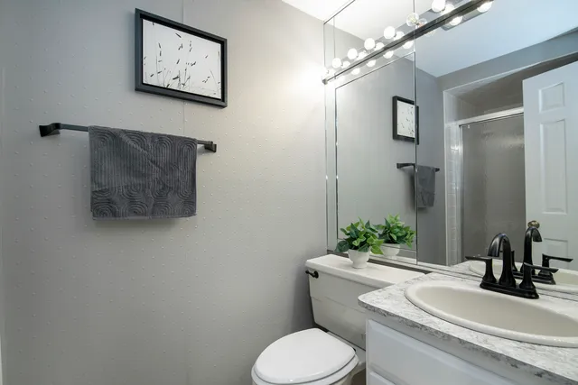 a bathroom with a toilet sink and mirror