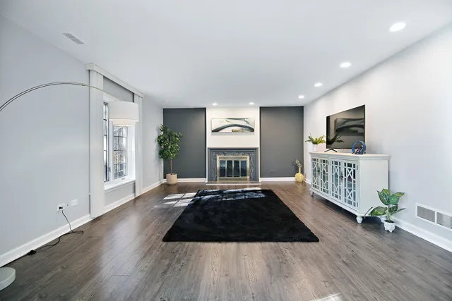 a large bedroom with wooden floor and furniture