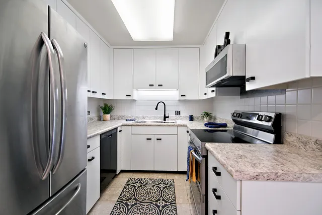a kitchen with stainless steel appliances granite countertop a refrigerator sink and stove