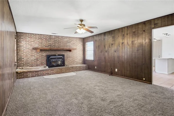 an empty room with windows and fireplace