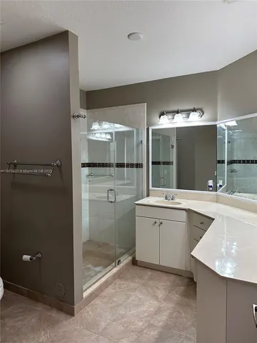 a bathroom with a sink mirror and shower