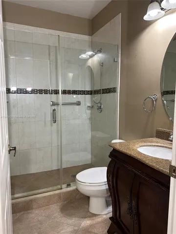 a bathroom with a granite countertop sink mirror toilet and shower