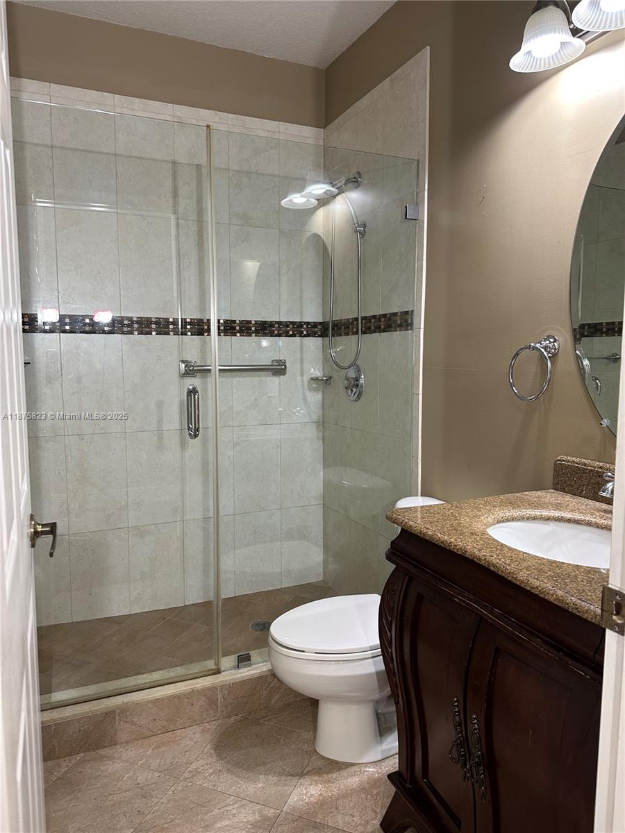 4959 Southwest 135th Way, Unit 4959 Miramar, FL 33027 - Photo 15 of 21 a bathroom with a granite countertop sink mirror toilet and shower