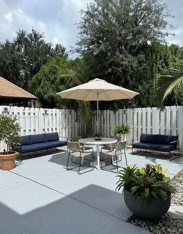 a view of a chairs and table in the back yard of the house