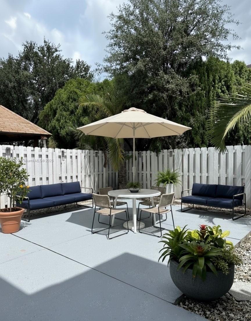 4959 Southwest 135th Way, Unit 4959 Miramar, FL 33027 - Photo 16 of 21 a view of a chairs and table in the back yard of the house