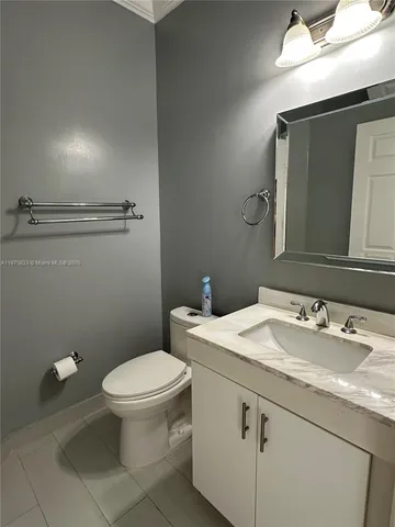 a bathroom with a granite countertop toilet sink and mirror