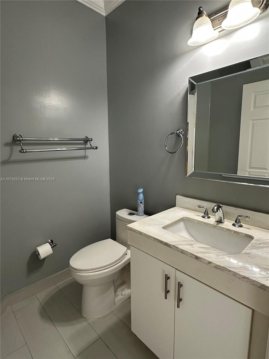 4959 Southwest 135th Way, Unit 4959 Miramar, FL 33027 - Photo 6 of 21 a bathroom with a granite countertop toilet sink and mirror