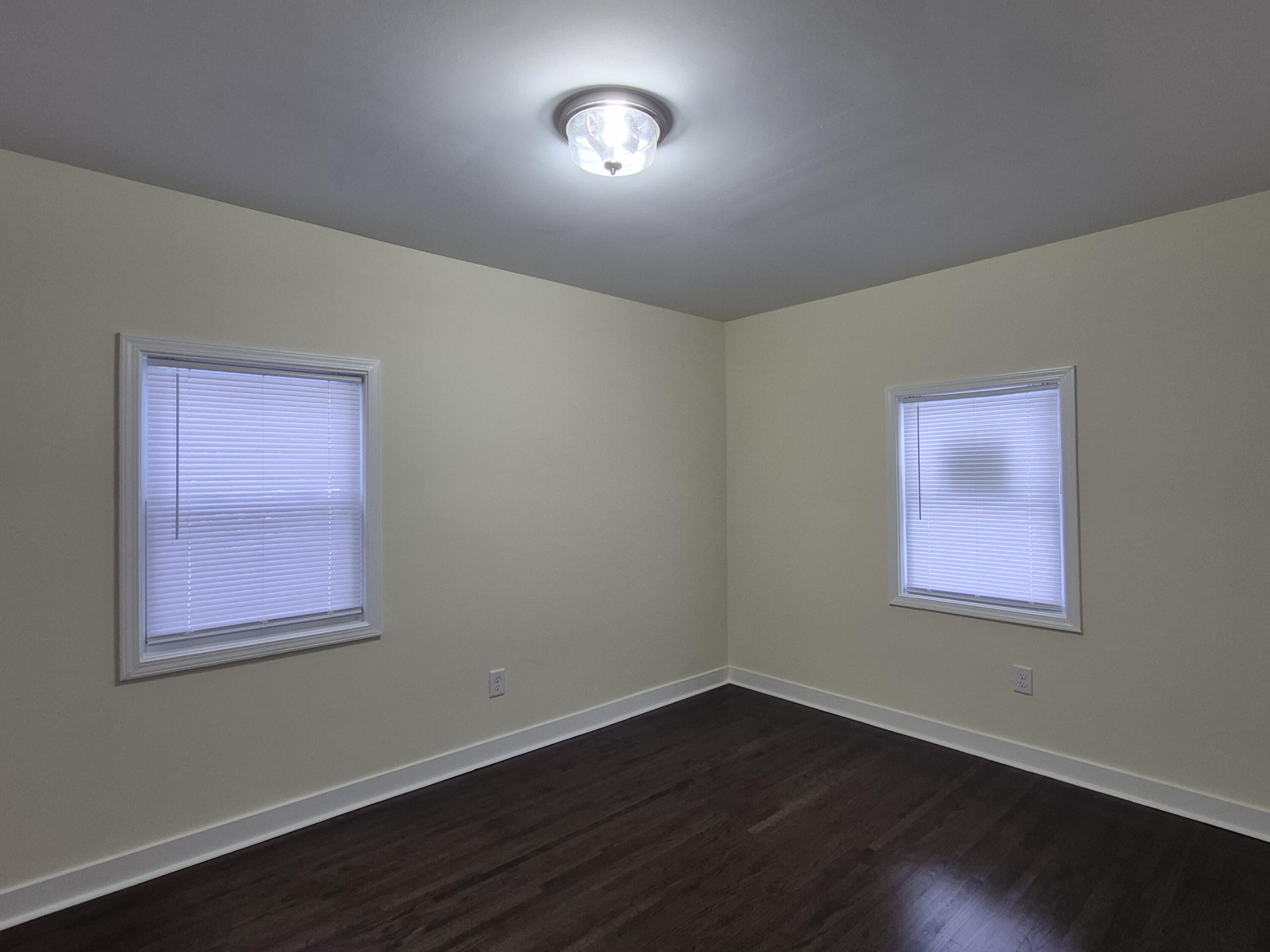 308 Pierce Street Gary, IN 46402 - Photo 12 of 23 a view of an empty room with wooden floor and a window
