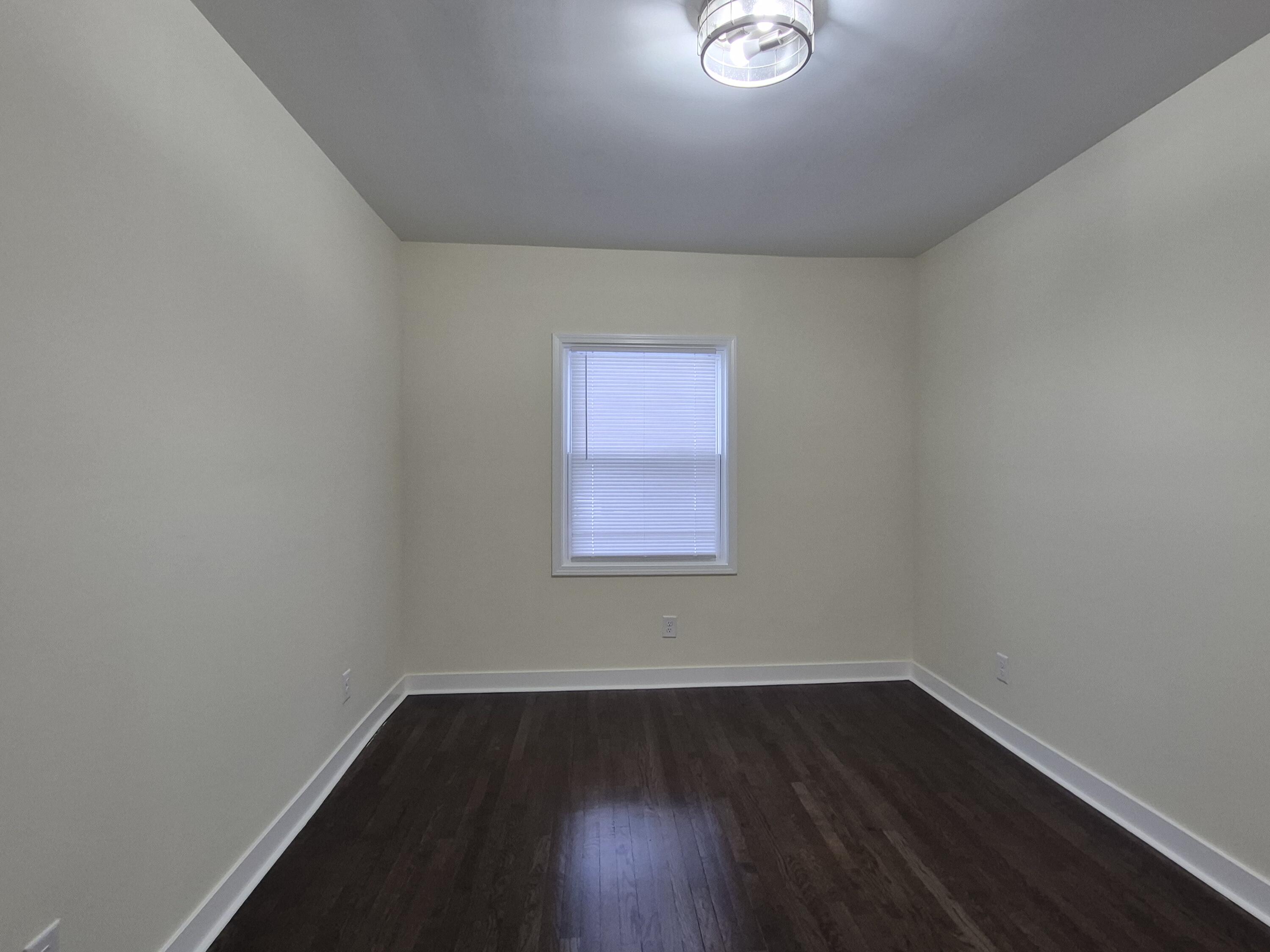 308 Pierce Street Gary, IN 46402 - Photo 14 of 23 a view of an empty room with wooden floor and a window