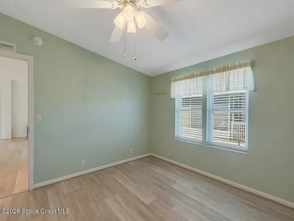 a view of a large room with wooden floor and windows