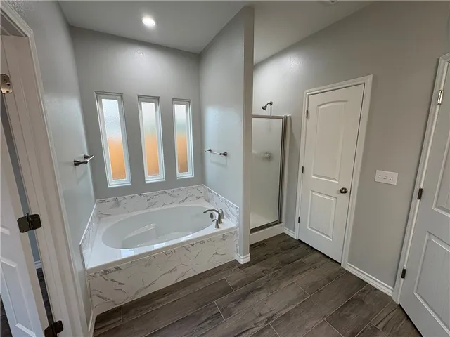 a bathroom with a tub shower and sink