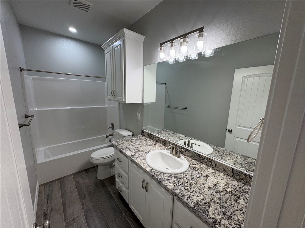 2533 Hewlett Ingleside, TX 78362 - Photo 17 of 23 a bathroom with a granite countertop sink a toilet and shower