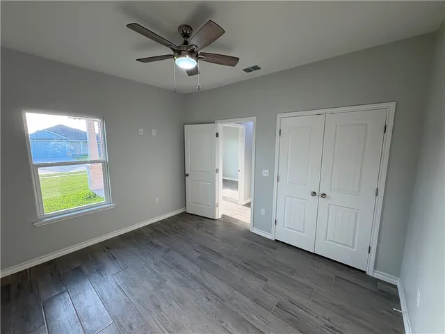 an empty room with window and wooden floor