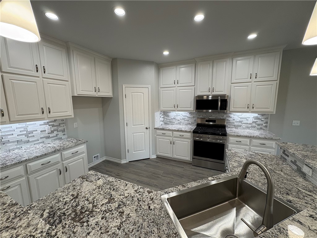 2533 Hewlett Ingleside, TX 78362 - Photo 7 of 23 a kitchen with granite countertop white cabinets and stainless steel appliances