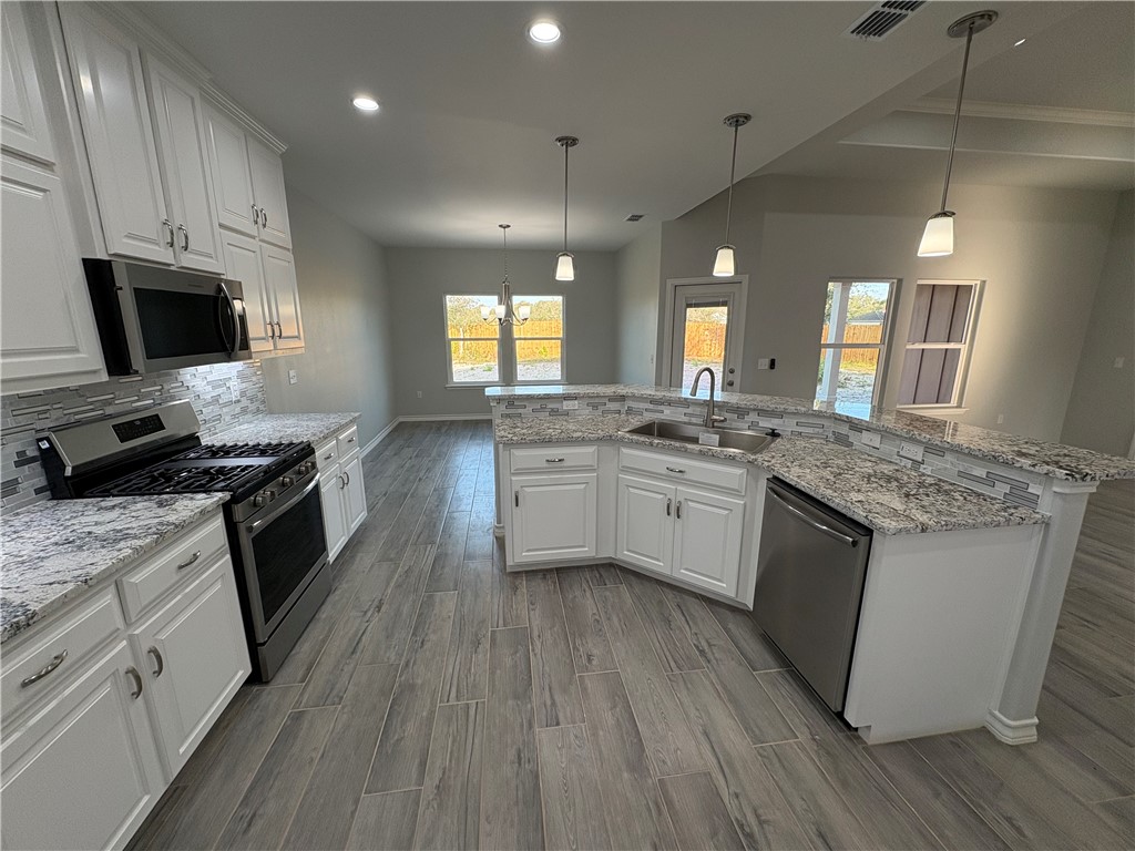 2533 Hewlett Ingleside, TX 78362 - Photo 8 of 23 a kitchen with granite countertop a sink wooden floor and stainless steel appliances