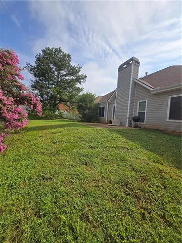 a backyard of a house with lots of green space and plants