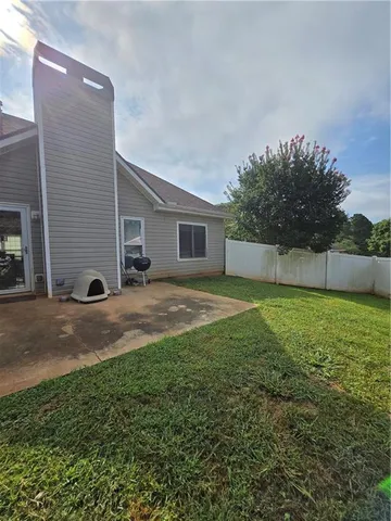 a view of backyard of house with green space