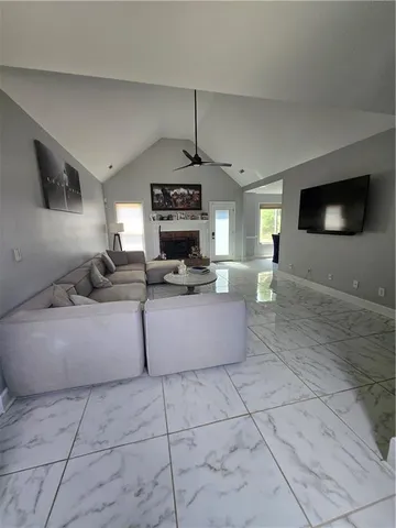 a living room with couches a flat screen tv and a fireplace