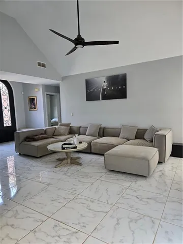 a living room with furniture and a ceiling fan