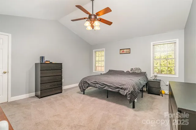 a spacious bedroom with a bed and a dresser