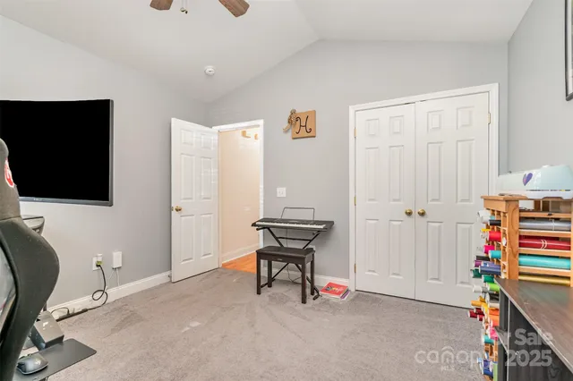 a view of an empty room with workspace and a flat screen tv