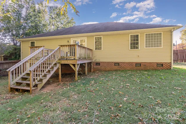 a view of a house with wooden stairs and a yard