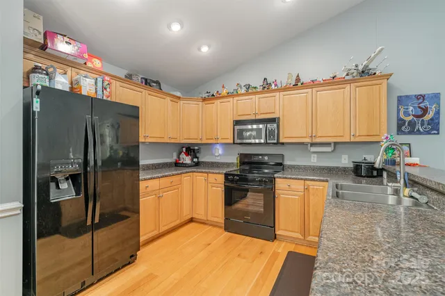 a kitchen with stainless steel appliances granite countertop a refrigerator and a stove top oven