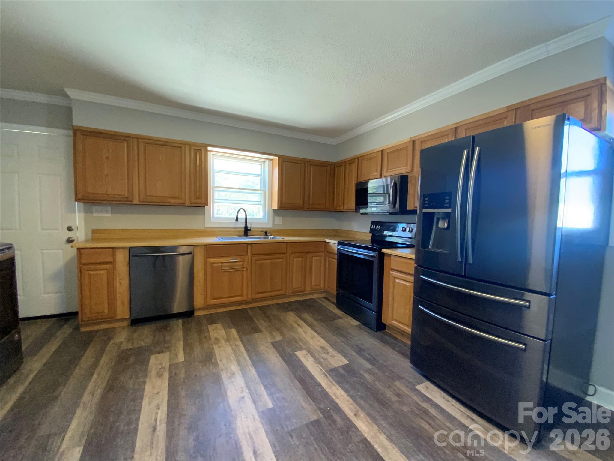 109 Fish Camp Road Forest City, NC 28043 - Photo 3 of 11 a kitchen with wooden floors stainless steel appliances and window