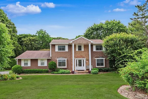 a front view of a house with a garden