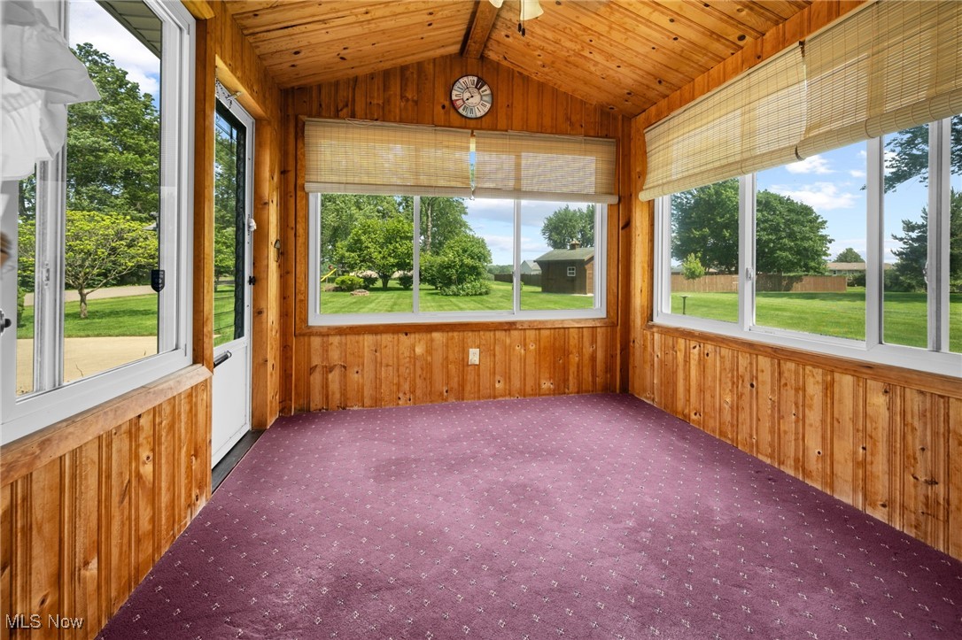 6944 Rolling Ridge Road Northeast Canton, OH 44721 - Photo 11 of 27 Unfurnished sunroom featuring wooden walls, vaulted ceiling, carpet flooring, and wood ceiling