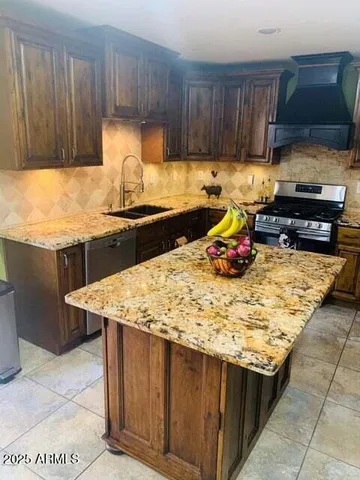 a kitchen with granite countertop a stove a sink and a stove